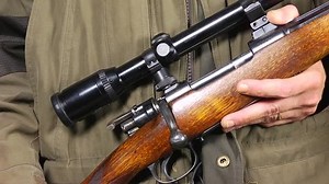 Slow motion of a hunter, reloading his rifle, ejecting the shell of the previously fired bullet
