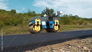 Road roller compacted asphalt on new road, completed work. Road roller - compactor-type engineering vehicle used to compact soil, gravel, concrete or asphalt in construction of roads and foundations