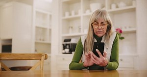 Caregiver, old woman and nursing home with technology assistance, cheerful and friendly helper in clinic. Women, diversity and carer of elderly patient with communication, cellphone and digital help