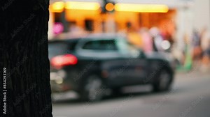 An urban street scene captures a slow motion view of a bus and pedestrians in motion, creating a dynamic cityscape