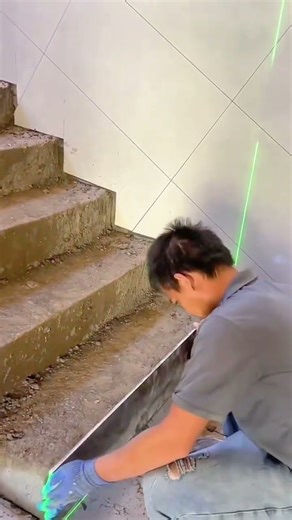 Measuring concrete stair steps using laser level alignment tool.