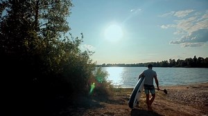Man Stand Up Paddle Boarding. Warm Summer Beach Vacation Holiday. Travel Paddles Paddleboard. Sup Board Journey. Bearded Man Relaxing On Sup Surf Swimming. Watersport Floating On Surfboard At Sunset