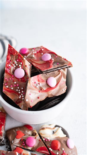 Karli | Family Food Blogger on Instagram: "Full recipe for Valentine Oreo Bark 👇💕 Ingredients 24 Oreo Thins 1 (4 oz) white chocolate bar, broken into pieces 1 (4 oz) milk chocolate bar, broken into pieces 1/4 cup red candy melts Valentine sprinkles Valentine M&M’s Instructions 1. Preheat oven to 180°F. 2. Line a cookie sheet with a silicone baking mat or parchment paper. 3. Arrange the Oreo Thins in a single layer on the prepared pan. 4. Sprinkle the white and milk chocolate pieces evenly over