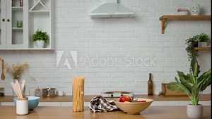 The housewife starts cooking in kitchen and puts on apron. Woman wears cloth that protects her clothes from dirt. The woman loves cooking and enjoys the process of preparing delicious, healthy dishes.