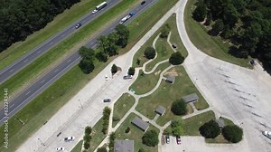 Rest area and tourist welcome center near Highway Interstate 10 (I-10) in Greenwood, Louisiana, USA with busy traffic on two lanes freeway and cars, semi-truck entering, leaving rest stops