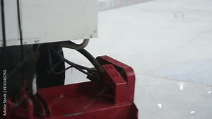 Resurfacer vehicle cleaning white ice rink surface, preparations for competition