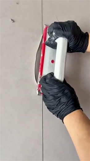 Worker Securing Wall Device Firmly During Installation Process