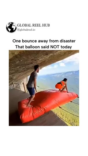 GLOBAL REEL HUB™ on Instagram: "Dm for Credit / Removal The post features a 10-second video of a woman bouncing on a red inflatable mat teetering on a cliffside platform in a mountainous area, narrowly avoiding a fall into the abyss, captioned to highlight the thrill of the near-miss. Posted on December 23, 2025, by @casmirtheking_ , it garnered over 2.4 million views and 1,400 likes within hours, sparking debates in replies about whether the footage is genuine or AI-generated, with the author i