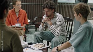 Stressed man discussing mental health problems with people and psychologist during group therapy session