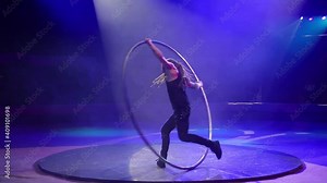 Performance of an acrobat with a ring on stage.
