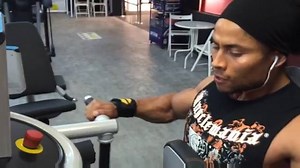 Musclemania® Physique Rodrigue Saker back training doing machine rows. Musclemania.com | Musclemania