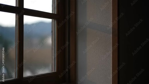 Time-lapse of sunset casting a moving shadow on a wall next to a window.