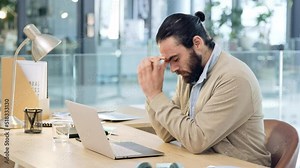 Angry young business man, feeling stress and the pressure of deadlines. Male web developer making a mistake while coding and banging his desk in frustration. Modern worker suffering from a headache