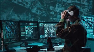 Military soldier operating advanced technology in a command center.