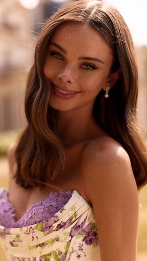 Our newest prom arrival features a strapless corset bodice, dreamy chiffon ruffles, and the most stunning green and purple floral print, made to turn heads! This 2026 prom arrival is giving garden goddess vibes! | The RoseTree Boutique