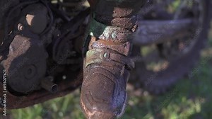Boots of a motocross rider after an exhausting race on a very muddy track.