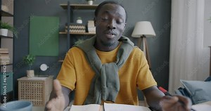 Portrait of African American entrepreneur speaking and showing business document making online video call from home. People and communication concept.
