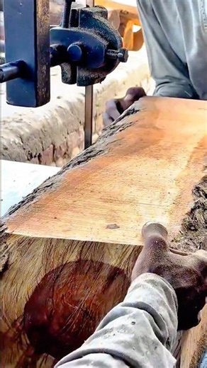 cutting a large raw wood log using a professional band saw machine to create fine art masterpieces