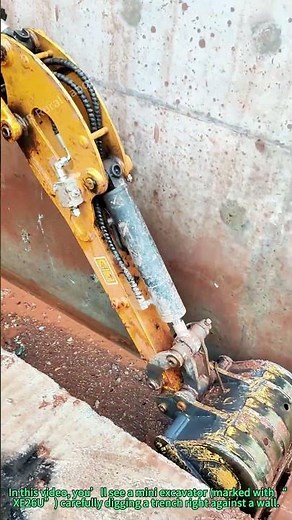 Mini Excavator Digging Trench Against Wall