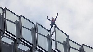 Climber scales Paris building in climate protest