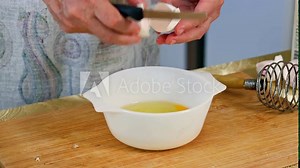 The chef breaks an egg. Break the egg into a glass bowl. The chef is preparing food. A man breaks an egg. Prepare ingredients for baking. Man's hands break a fresh egg.
