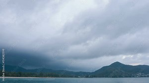 4k video - Timelapse video of stormclouds growing and thickening from a light gray to a deep, ominous steel blue color over a tropical beach in Thailand.