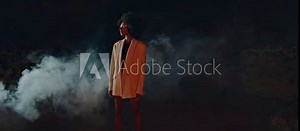 Trendy lady modeling smoke fog on beach. Attractive slim woman looking camera