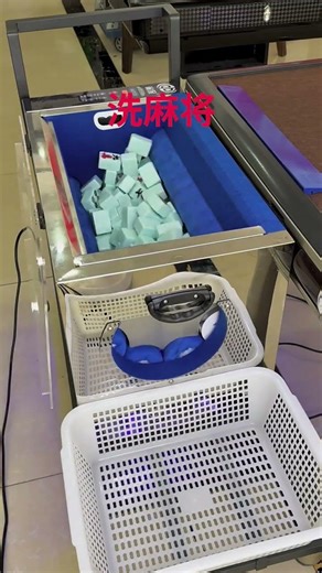 automatic mahjong table with the playing surface and a compartment filled with mahjong tiles.