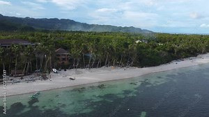 Beach on Bohol Island in Philippines is one of most popular tourist destinations in Philippines. Beach with coastal village bordered by high coconut palms and azure waters. Tropical paradise in Bohol.