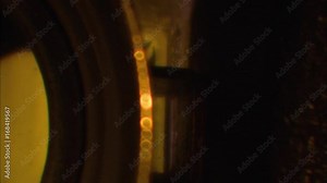 Revolving closeup of lens of old film projector.