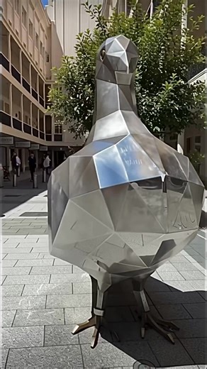 The sculpture is called Pigeon. It’s by South Australian artist Paul Sloan. ￼It’s made of mirrored stainless steel, giving it a shiny, reflective surface. ￼ The sculpture stands over 2 metres tall (some sources say about 2.3 m). ￼ You’ll find it at the southern end of Rundle Mall at the entrance to Gawler Place, near the Nespresso store. ￼ It sits close to some of the Mall’s other familiar sculptures (like the “Mall’s Balls” and the bronze pigs). ￼ Paul Sloan created “Pigeon” to celebrate the hu