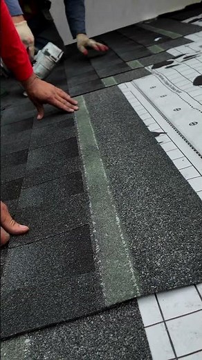 Close up of an asphalt roof shingle being installed