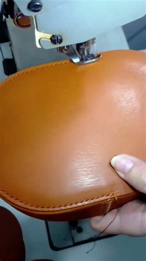Stitching leather material with industrial sewing machine to form smooth curved edges preciselyyy