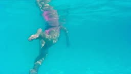 Young woman swims and dives in the beautiful swimming pool,Video clip