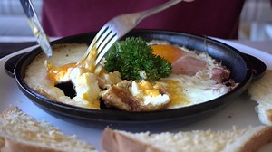 Download Man Eating Traditional Breakfast With Fried Eggs, Toast and Salad for free