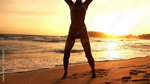 Woman in bikini exercising, doing jumping jacks on beach, super slow motion 240fps