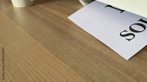 Printing “NO SOLICITING” text written message word on paper sheet document. Close up A4 page being printed from multifunction scanner printer on wooden desk in office. Hand take paper from printer