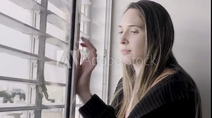 Woman looking out the window shutters smiling closing and opening window glass and shutters. beautiful lady in morning looking out the blinds to the street. closing shutters close up. Positive happy