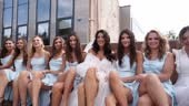 Attractive bride and bridesmaids switching crossing legs sitting on...