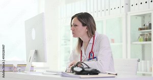 Lady doctor studies attentively patient tests results looking at computer monitor. Therapist finds problem in examination data at workplace