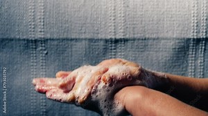 Woman washing hands with soapy suds and water