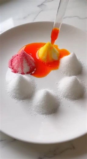 🌈💥 Rainbow Sugar Crystal Volcano Reaction This colorful crystal volcano effect is made using simple kitchen ingredients. When a warm sugar solution saturates dry sugar and baking soda reacts with vinegar, the structure expands into bright foamy mounds that later dry into textured crystal formations. Here is the complete method. 🧪 Materials • Granulated sugar • Very hot water • Food coloring (assorted colors) • Baking soda • White vinegar • Small cups • Spoons • A shallow plate Step 1: Form th