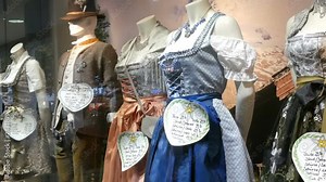 Beautiful various women's national Bavarian costumes dirndl on shop window