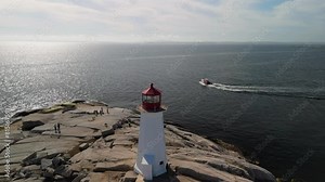 Drone view coast with lighthouse and lobster fishing boat Peggy's Cove.Famous Peggy's Point Lighthouse, standing tall against backdrop sea, would be a focal point, guiding ships safely along coastline