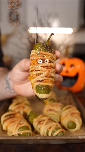 Mummy Jalapeño Poppers 👻 Recipe ⤵️⤵️⤵️ This has been my go to appetizer for Halloween and always is a hit! 🎃👻 Makes 9 Poppers Ingredients: 9 Jalapeños 1 Puff Pastry Sheet 5 Strips of Thin Bacon 6 oz Cream Cheese 1 Cup Shredded Cheddar Cheese Edible Eyes 👀 I found at Walmart for $3.88 2 oz Hot Honey How to: 1. Hollow out the jalapeño into a boat 2. Add cream cheese, cheddar cheese, and bacon in the jalapeño boats 3. Slice the Pastry sheets in very thin slices 4. Wrap the Pastry slices around 