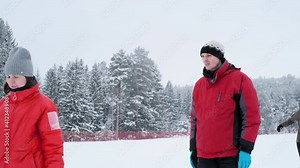 Ski trainer and students. Male trainer explains to his students proper ski technique being outdoor on the cross country ski track