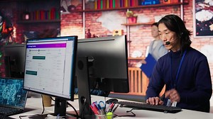 Call center senior agent providing step by step guidance to help customers using AI. Customer center worker at PC desk walking clients through technical solutions using artificial intelligence