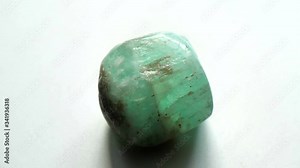 Beryl emerald is a natural stone mineral, a collection of natural stones on a gray background. A beautiful stone emerald. Natural mineral rough emerald beryl gemstone crystal on gray background.