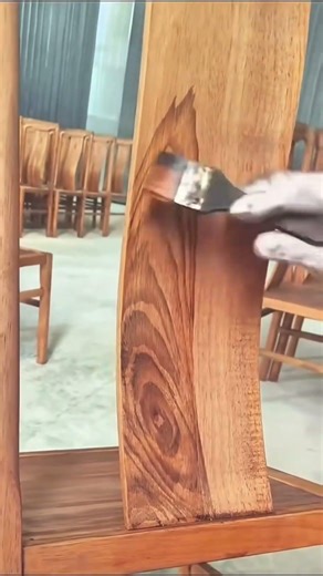 Applying wood stain to a furniture piece to enhance the natural grain and texture