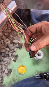 The technician soldering frayed wires on a car and insulating them with heat shrink tubing. Auto electrician repairing the wiring of a car at an auto service. Stock Video